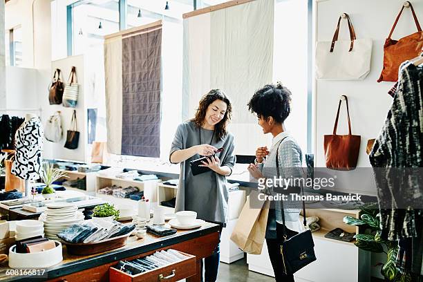 owner processing credit card with digital tablet - paying stock pictures, royalty-free photos & images