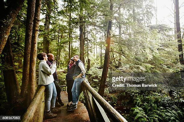 woman taking photo of friends with smartphone - washington state trees stock pictures, royalty-free photos & images