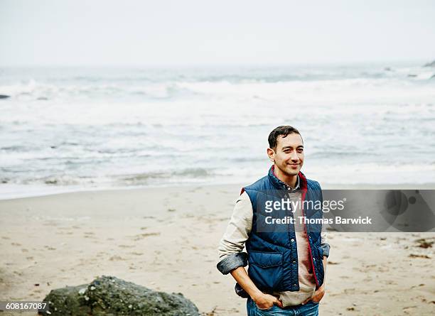 smiling man hiking on beach - vest fotografías e imágenes de stock