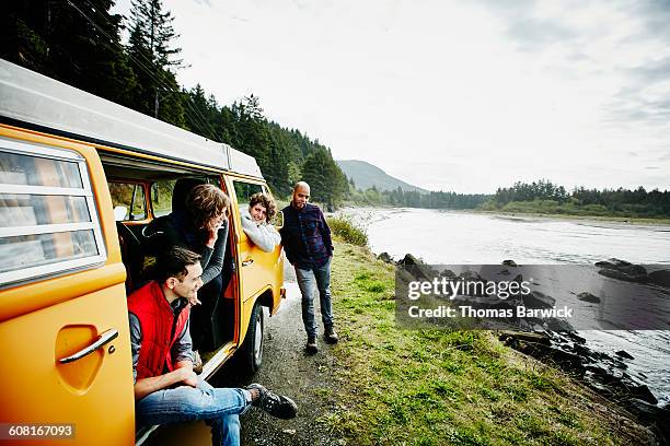 Group of friends on road trip parked by ocean