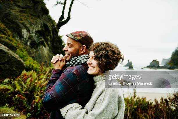 laughing couple embracing at beach overlook - candid mature couple outdoors stock-fotos und bilder