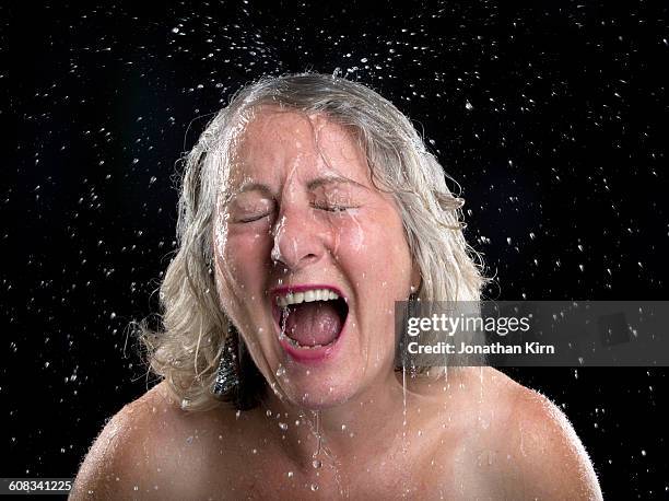 mature woman reacts to having water sprayed on her - wet hair stock pictures, royalty-free photos & images