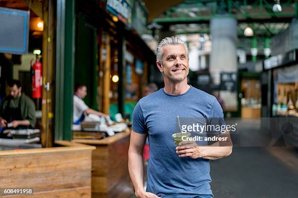 healthy man having a smoothie - mature men stock pictures, royalty-free photos & images