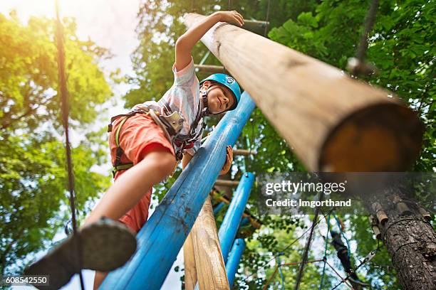 little boy at outdoors ropes course obstacle - abseiling stock pictures, royalty-free photos & images