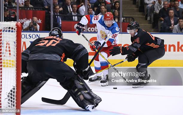 Evgeny Kuznetsov of Team Russia stickhandles the puck in on Matt Murray with pressure from Morgan Rielly of Team North America during the World Cup...