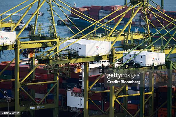 Stacked containers sit behind gantry cranes at Tanjong Pagar Container Terminal, operated by PSA International Pte, at the Port of Singapore in...