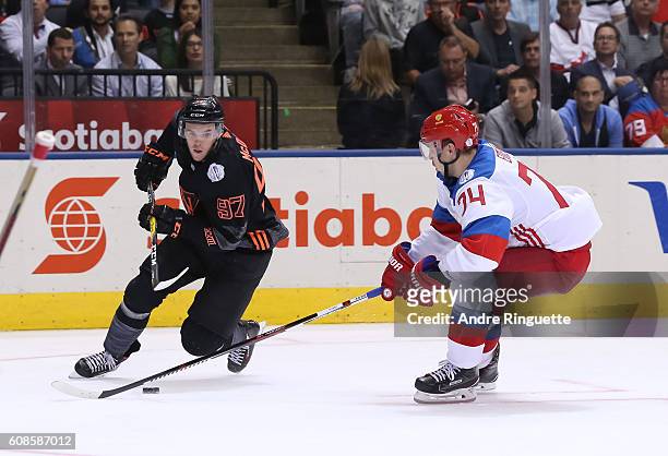 Connor McDavid of Team North America stickhandles the puck away from Alexei Emelin of Team Russia during the World Cup of Hockey 2016 at Air Canada...