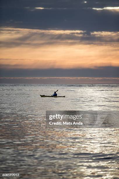 man kayaking in sunset in lofoten, norway - sole di mezzanotte foto e immagini stock