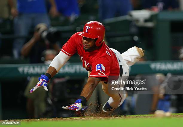Elvis Andrus of the Texas Rangers slides in to score in the ninth inning to end the game against the Los Angeles of Angels Anaheim at Globe Life Park...