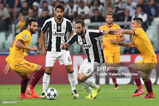 Gonzalo Higuain of Juventus FC is challenged by Matias Kranevitter of Sevilla FC during the UEFA Champions League Group H match between Juventus FC...