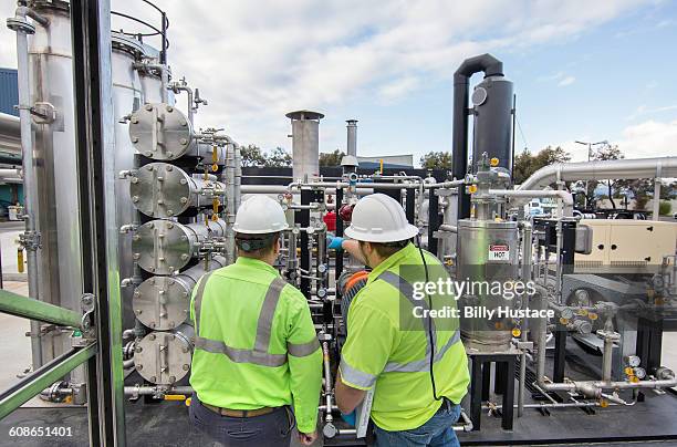 worker inspecting a solid waste processing plant - biogas stock-fotos und bilder