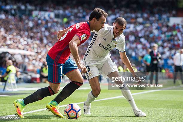 Pepe of Real Madrid battles for the ball with Unai Garcia of Osasuna during the La Liga match between Real Madrid and Osasuna at the Santiago...