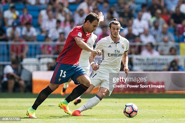 Gareth Bale of Real Madrid battles for the ball with Unai Garcia of Osasuna during the La Liga match between Real Madrid and Osasuna at the Santiago...