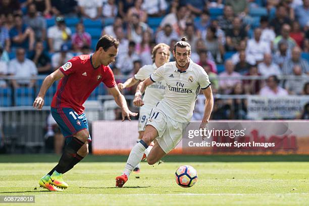 Gareth Bale of Real Madrid battles for the ball with Unai Garcia of Osasuna during the La Liga match between Real Madrid and Osasuna at the Santiago...