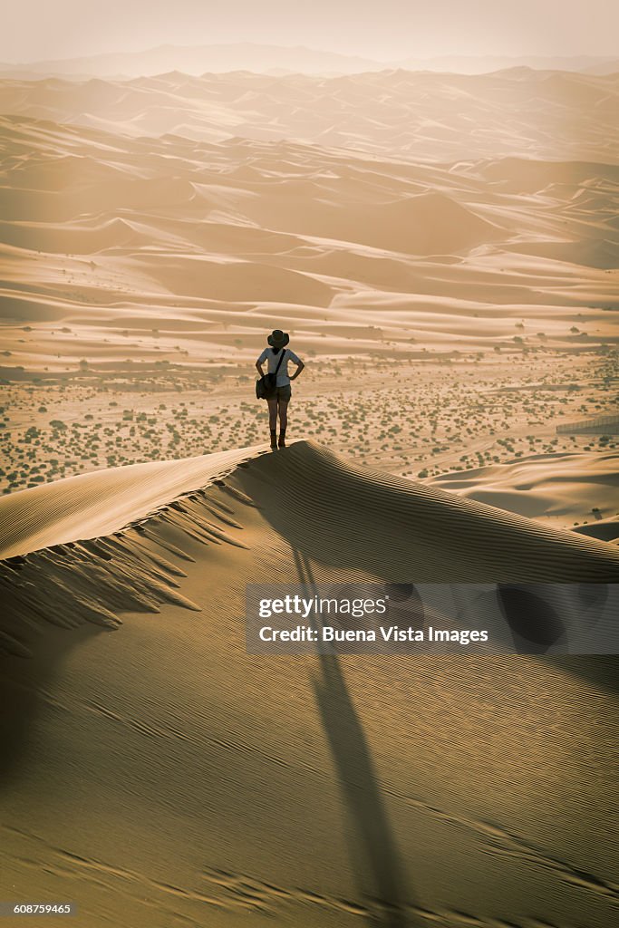 Woman on a sand dune at sunset