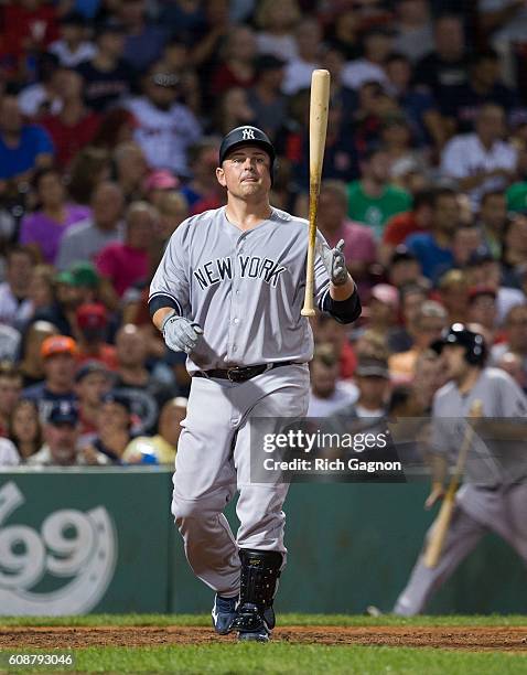 Billy Butler of the New York Yankees reacts after swinging and missing a pitch during the fourth inning against the Boston Red Sox at Fenway Park on...
