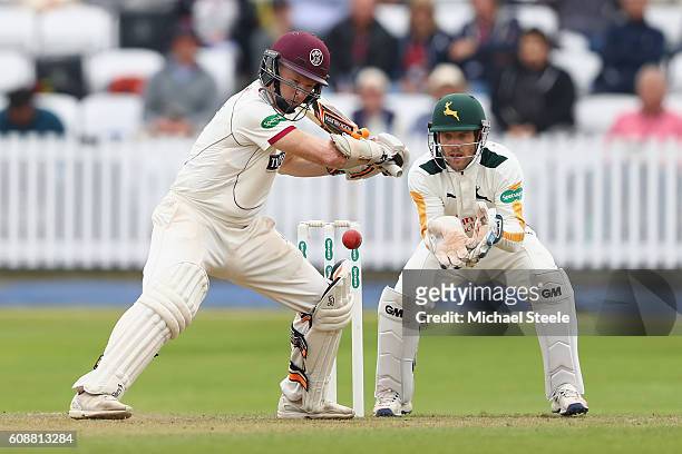 Chris Rogers of Somerset cuts a delivery from Matthew Carter as wicketkeeper Chris Read looks on during day one of the Specsavers County Championship...