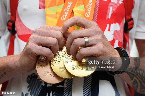 Gold medallist Adam Duggleby holds his medals after arriving on British Airways flight BA2016 from Rio de Janeiro to London Heathrow Terminal 5 on...