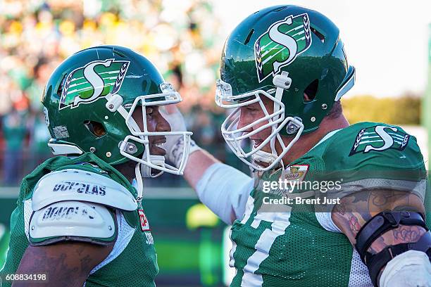 Darian Durant is congratulated by Dan Clark of the Saskatchewan Roughriders after scoring the game winning touchdown in overtime in the game between...