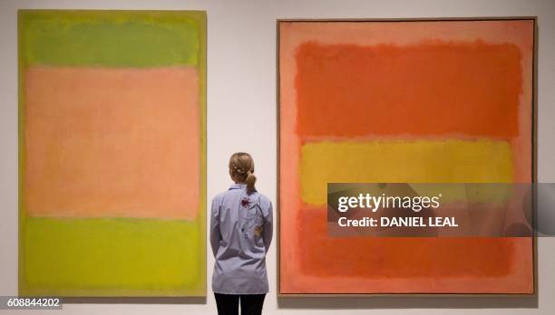 Gallery assistant poses in front of paintings entitled 'Untitled, 1954' and 'Untitled, 1949' by US artist Mark Rothko, during a photocall to promote...