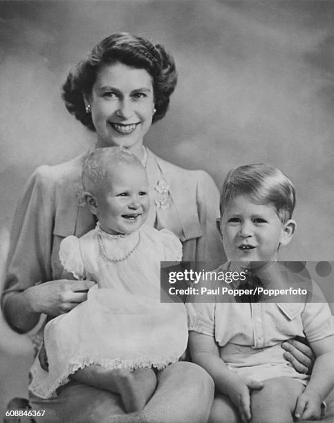 Princess Elizabeth with her baby daughter Princess Anne, and son, Prince Charles, July 1951. The portrait was taken to mark Anne's first birthday.