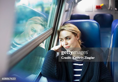 Young woman on a train looking out the window Young woman on a train looking out the window
