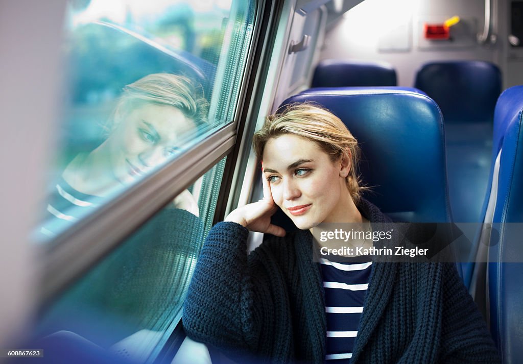 Young woman on a train looking out the window