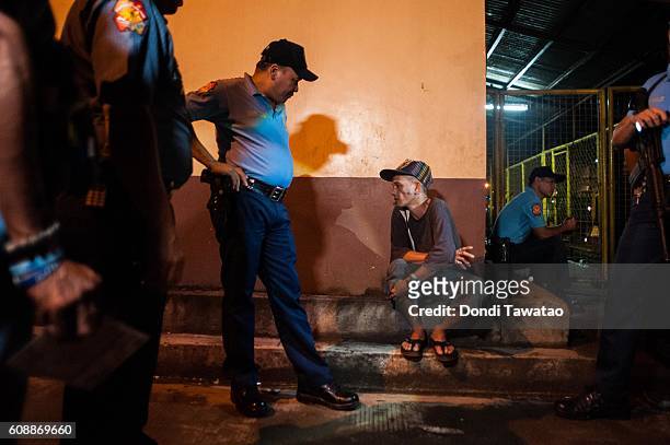 Police question a suspected drug user during a late night patrol at a shanty community on September 16, 2016 in Manila, Philippines. The death toll...