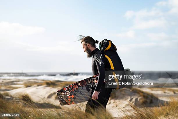 kitesurfer with equipment walking in sand dunes - hvide sande denmark stock pictures, royalty-free photos & images