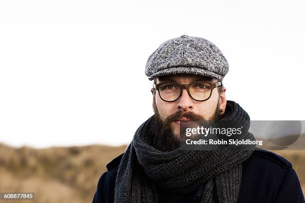 portrait of man with beard, sixpence and scarf - platte pet stockfoto's en -beelden