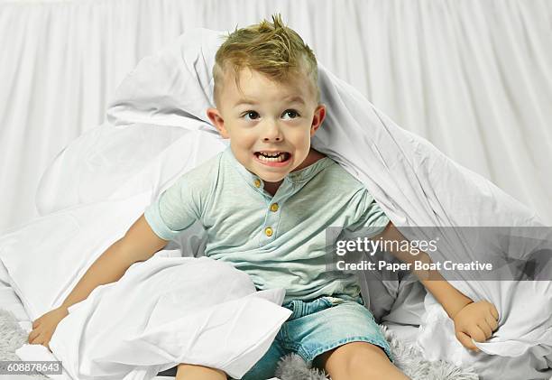 young boy playing under white bed sheets - boy hair gel stock pictures, royalty-free photos & images
