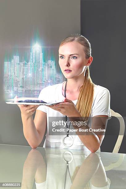 woman looking at a hologram of a cityscape - holographic-map fotografías e imágenes de stock