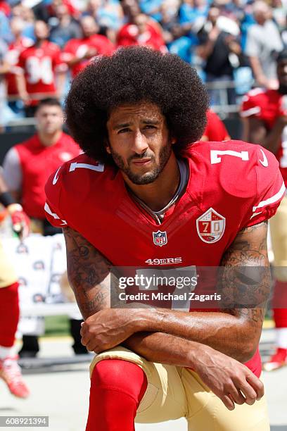 Colin Kaepernick of the San Francisco 49ers kneels during the anthem prior to the game against the Carolina Panthers at Bank of America Stadium on...