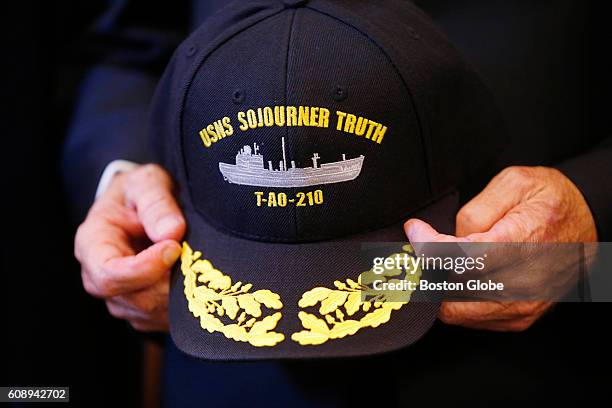 Secretary of the Navy Ray Mabus holds a hat of one of the new navy ships as he poses for a group photo following his announcement of two new ships of...