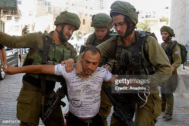 Israeli soldiers detain a Palestinian man as they conduct raid at homes belonging to Palestinians in Hebron, West Bank on September 20, 2016.