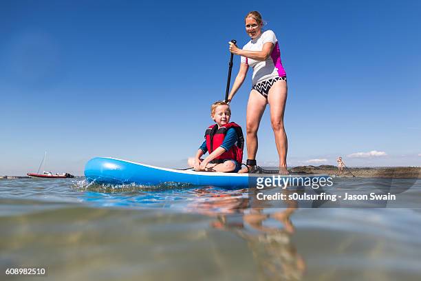 family stand up paddleboarding on the isle of wight. - s0ulsurfing stock pictures, royalty-free photos & images