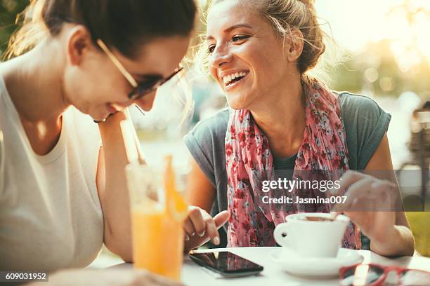 weibliche freunde im café sprechen - kaffee trinken stock-fotos und bilder