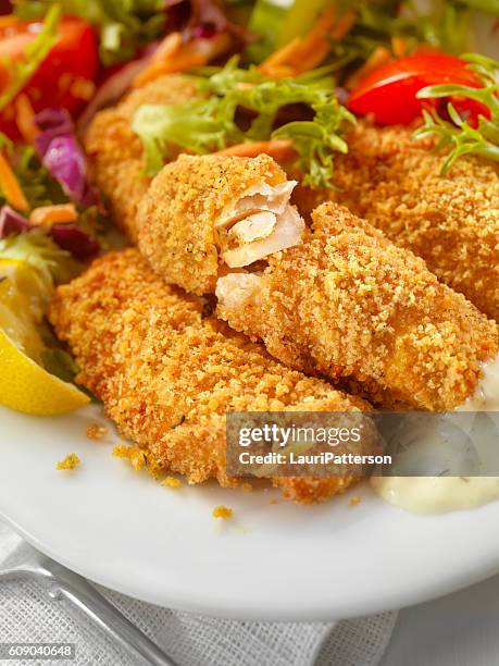 breaded and baked fish sticks with tarter sauce - fish fingers stockfoto's en -beelden