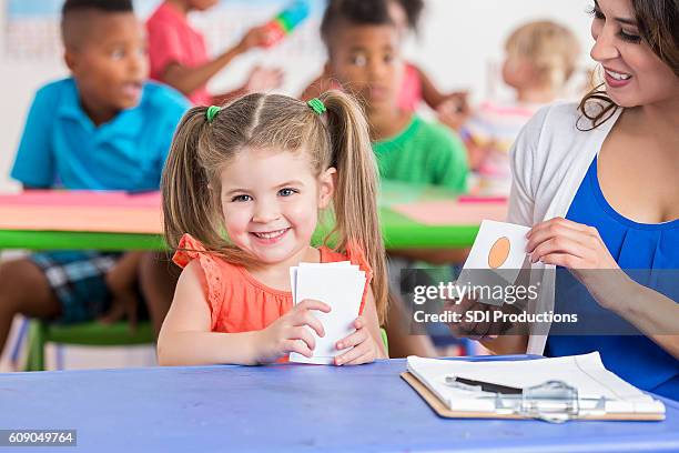 cute little girl working on flashcards with daycare teacher - bildkort bildbanksfoton och bilder