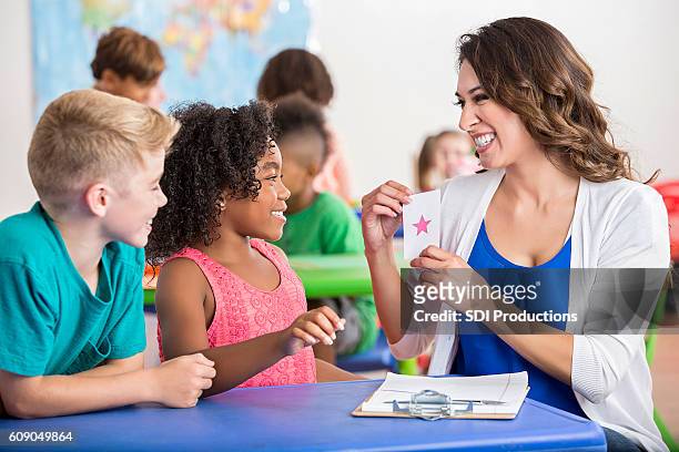 delightful teacher using flashcards with eager students - flash card stock pictures, royalty-free photos & images