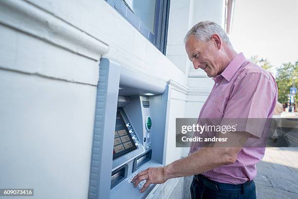 man withdrawing money from an atm - europe bank machine stock pictures, royalty-free photos & images