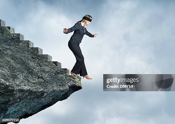 blindfolded businesswoman about to step off stairs - blinddoek stockfoto's en -beelden