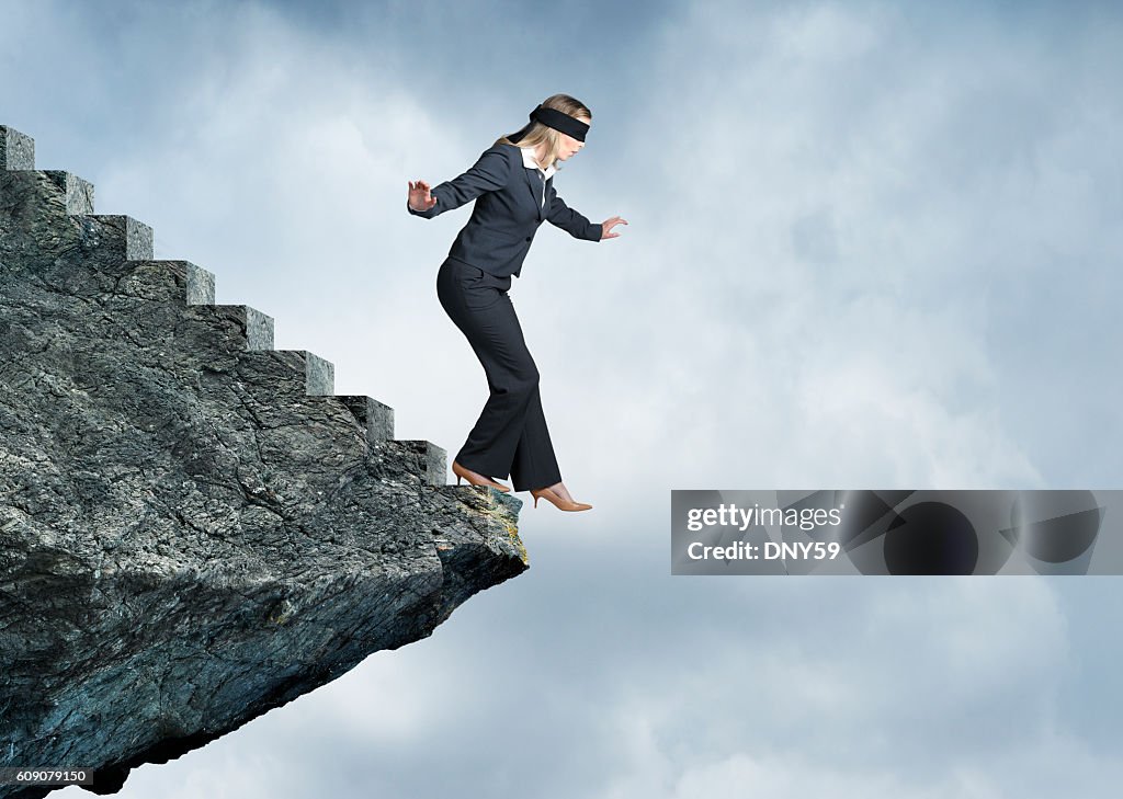 Blindfolded Businesswoman About To Step Off Stairs