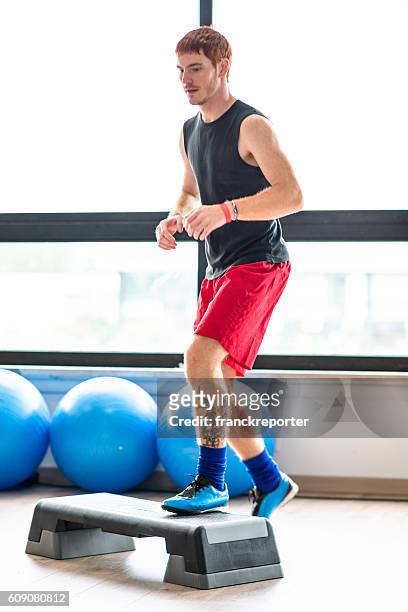 mann, der aerobic im fitnessstudio macht - aerobic stock-fotos und bilder