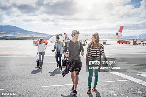 passagiere steigen an einem sonnigen tag aus dem flugzeug - passengers departures stock-fotos und bilder