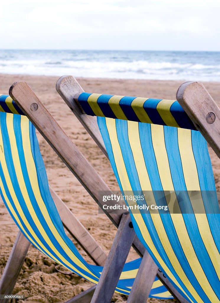 Deckchairs on sandy beach