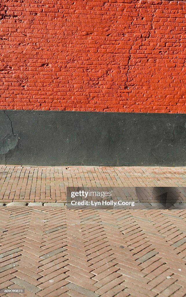 Red brick wall and paved street