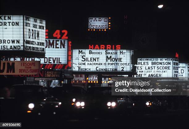 View of the marquees of cinemas on West 42nd Street including the New Amsterdam Theatre, Cine 42, the Harris Theater and the Liberty Theatre in 1976...