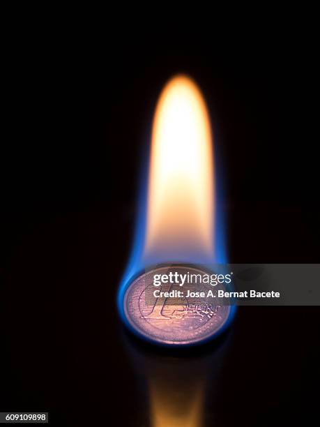 currency of an euro in flames, burning - 1 euro stock-fotos und bilder