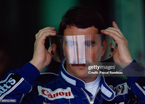 Nigel Mansell of Great Britain, driver of the Canon Williams Renault Williams FW14 Renault RS3C V10 looks through his visor before the the Canadian...